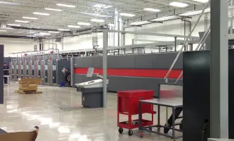 Industrial printing facility with large gray and red printing machines.